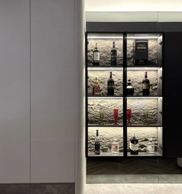 Tủ rượu cánh kính nhỏ xinh với điểm nhấn tấm ốp lưng giả bê tông.