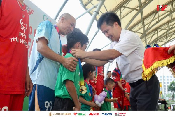 Ông Đỗ Cao Cường - Trưởng Phòng Đào tạo và Quản lí học viên PVF trao huy chương cho các "bố siêu nhân" cùng các con sau trận giao hữu.